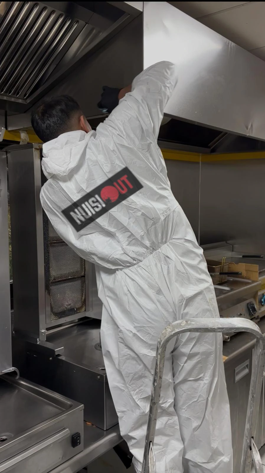 Homme nettoyant un mur avec aspirateur